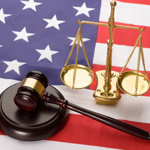 The image features a judge's gavel and scales of justice on an American flag, representing the need to comprehend federal crimes. - Law Offices of Donald J. Matson, PC